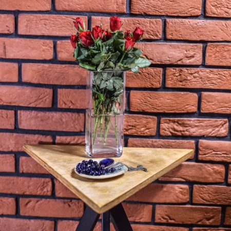Dreieckiger Industrie-Couchtisch T1 mit einer Vase mit Rosen