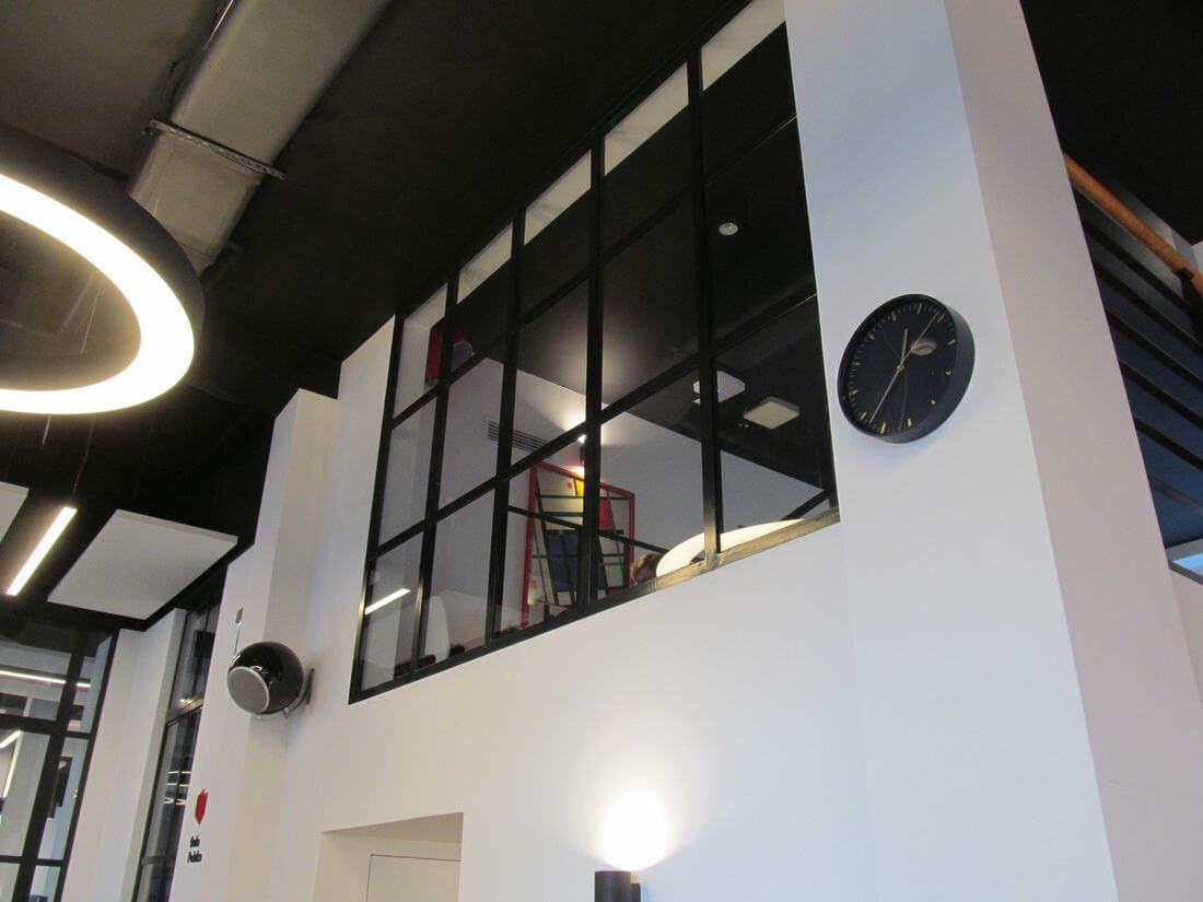 Loft wall system made of structural steel and reinforced glass 33.1 separating offices from the Charity café