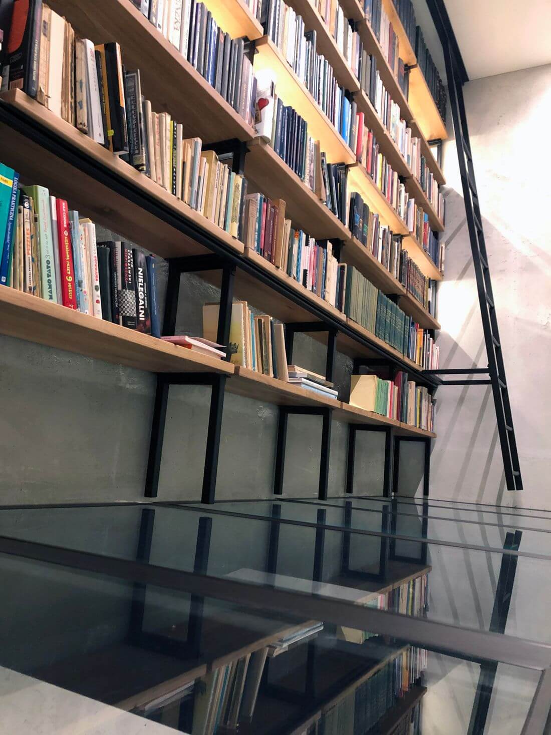 Tempered glass floor on the mezzanine Loft - Entresol Loft with a library made in loft industrial style of structural steel