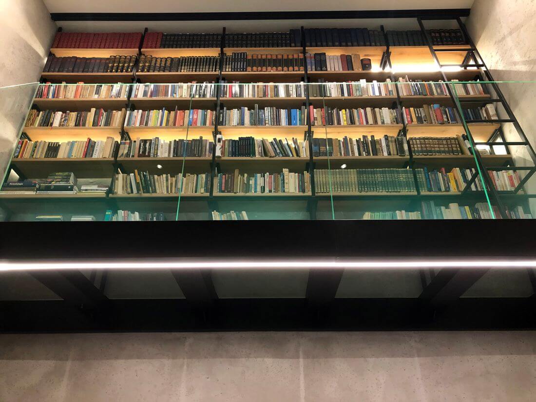 Biblioteka loft w stylu angielskim na metalowej loftowej szklanej antresoli w loftowym stylu z metalu, szkła hartowanego