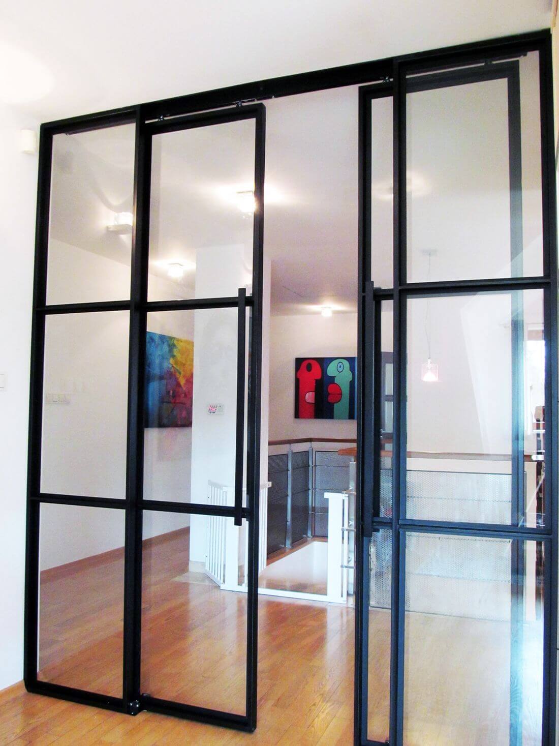 Drzwi Loftowe Przesuwne ze szklanymi przegrodami oraz bocznymi ściankami loftowymi w mieszkaniu w Warszawie